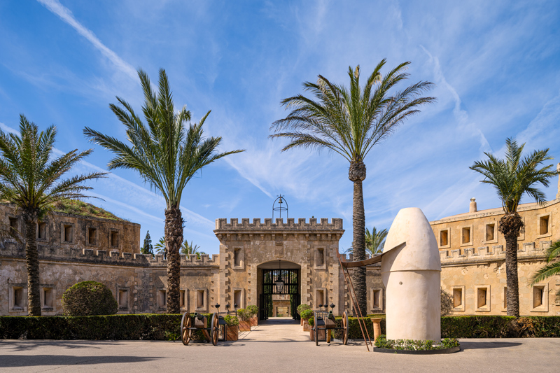 Cap Rocat stone fortress entrance with palm trees in Mallorca