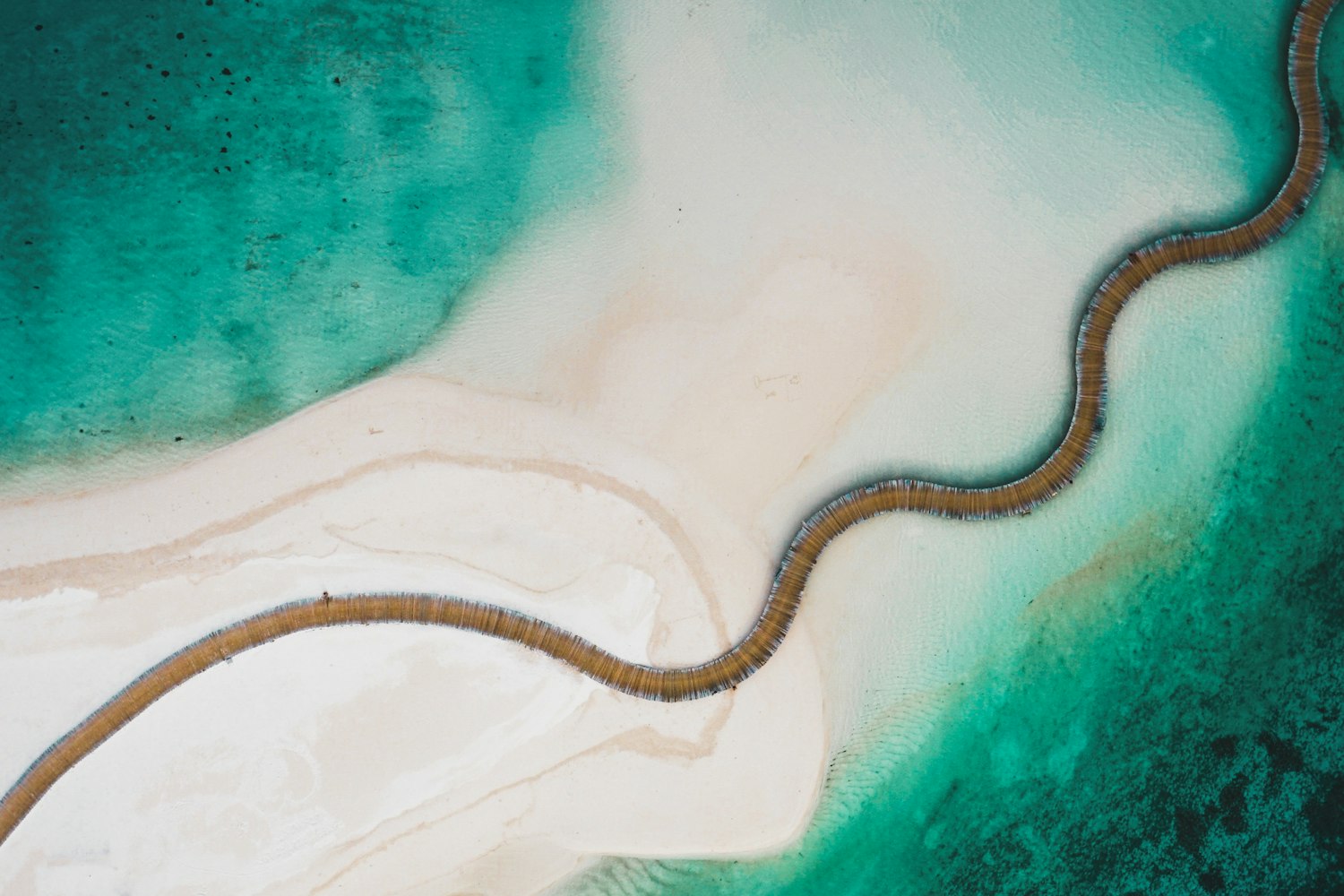 Winding lagoon boardwalk and overwater villas at Soneva Jani, Maldives