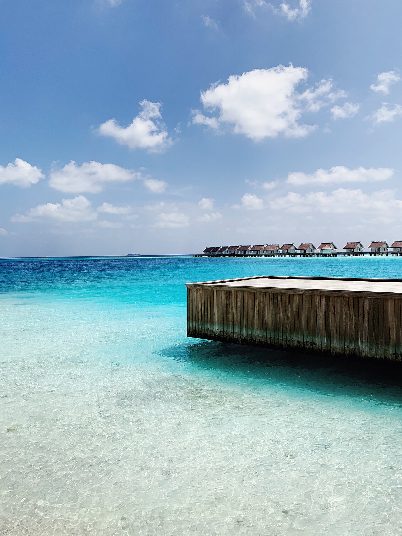 Overwater bungalows above a bright blue Maldives lagoon