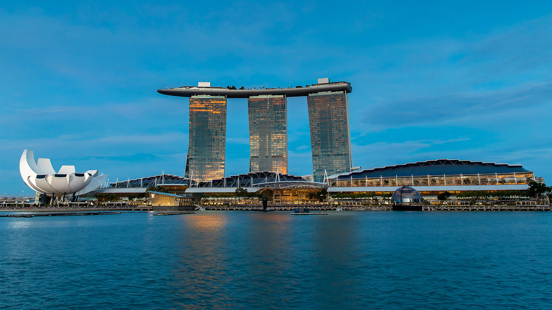 Marina Bay Sands towers and SkyPark lit above Singapore at dusk